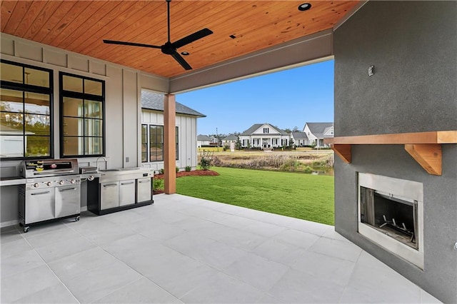 view of patio / terrace featuring sink, area for grilling, exterior fireplace, and ceiling fan