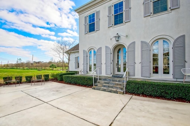 view of exterior entry featuring a patio area and french doors