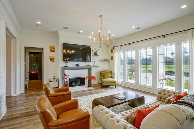 living room featuring an inviting chandelier, crown molding, and light hardwood / wood-style floors