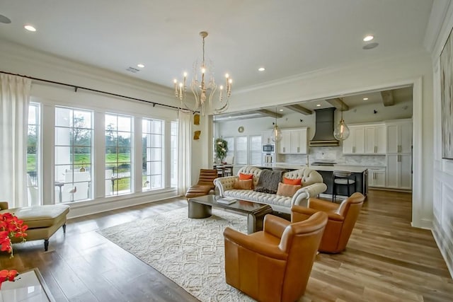 living room featuring a notable chandelier, crown molding, and light hardwood / wood-style flooring