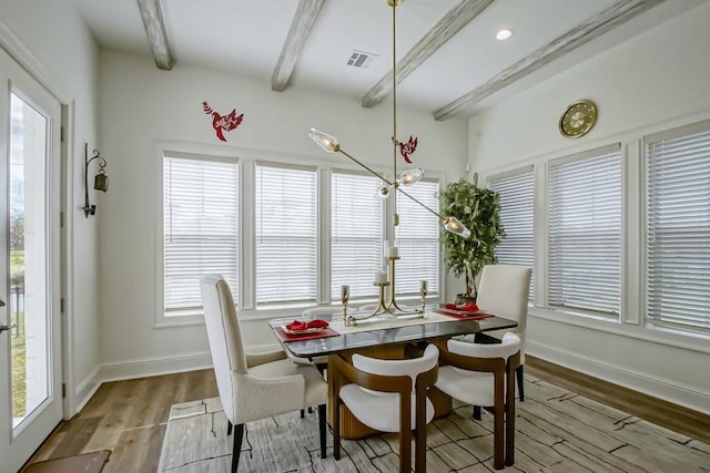 dining room with light wood-type flooring and beam ceiling