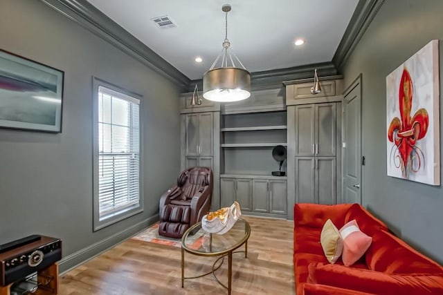 sitting room with light hardwood / wood-style floors, built in features, and crown molding