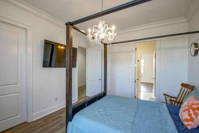 bedroom featuring a chandelier, dark hardwood / wood-style floors, and ornamental molding