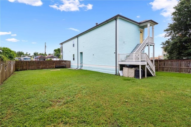 back of property with a wooden deck and a yard