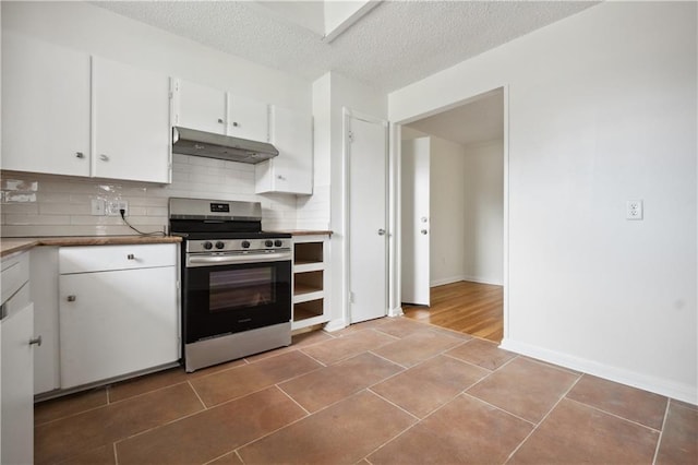 kitchen featuring backsplash, stainless steel range, a textured ceiling, white cabinets, and tile patterned flooring