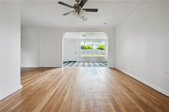 spare room featuring ceiling fan, a textured ceiling, and light wood-type flooring