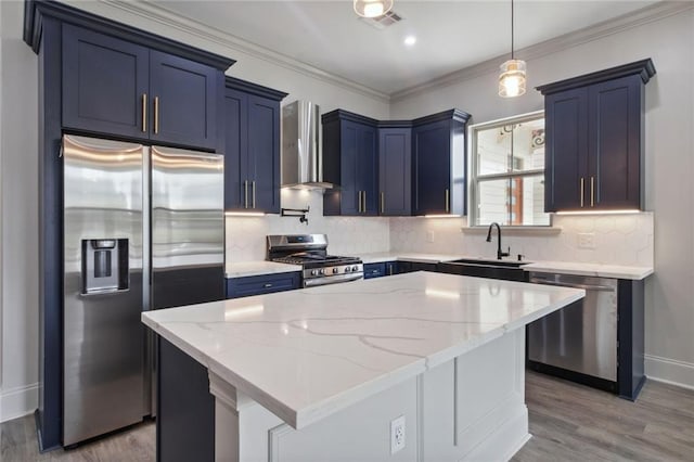 kitchen with a center island, wall chimney range hood, stainless steel appliances, sink, and light stone counters