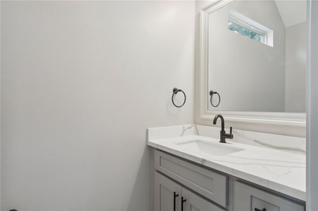 bathroom with lofted ceiling and vanity