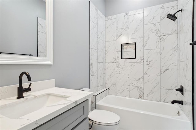 full bathroom with toilet, tiled shower / bath, and vanity