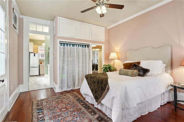 bedroom with ceiling fan, white fridge, crown molding, and dark wood-type flooring