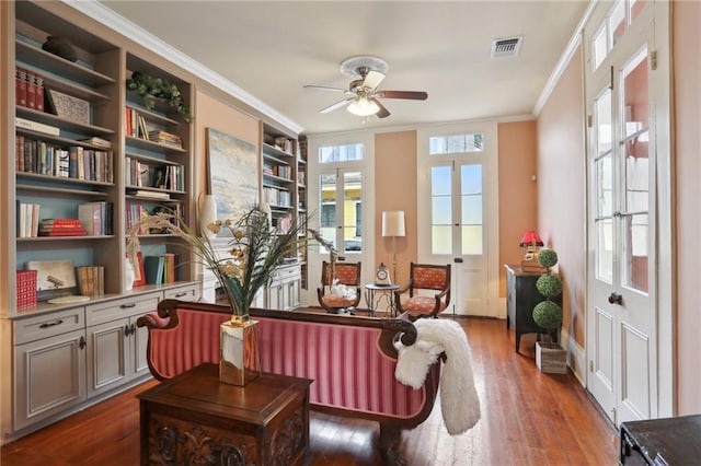 sitting room with french doors, crown molding, ceiling fan, built in features, and dark hardwood / wood-style flooring