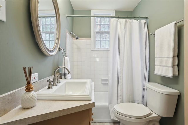 bathroom featuring a shower with curtain, toilet, and vanity