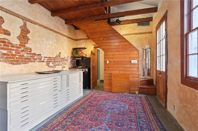 interior space featuring vaulted ceiling with beams and wooden ceiling