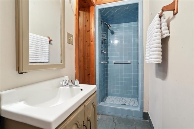 bathroom with a tile shower, tile patterned floors, and vanity