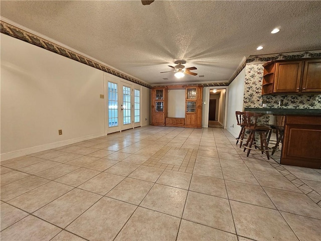 kitchen featuring ceiling fan, light tile patterned floors, a textured ceiling, and ornamental molding