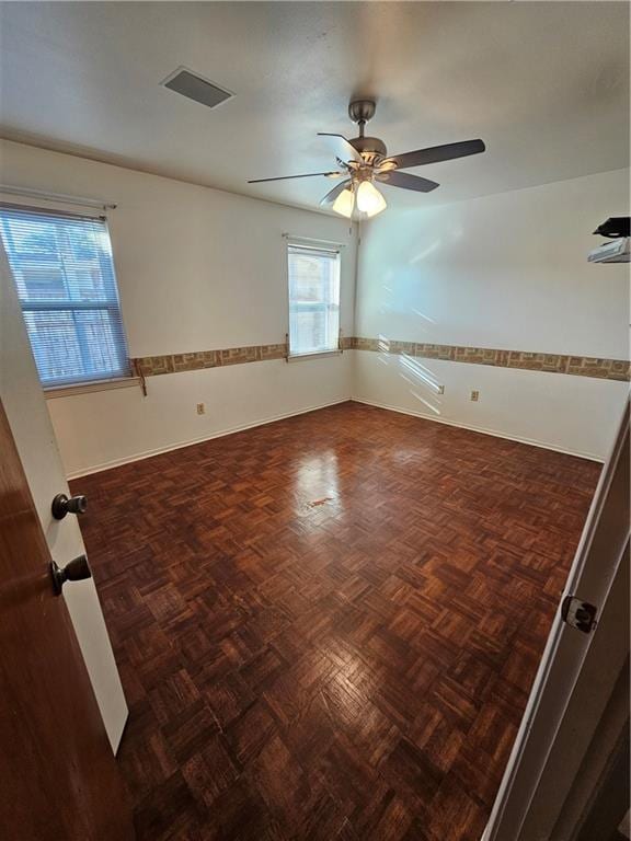 spare room with dark parquet flooring and ceiling fan