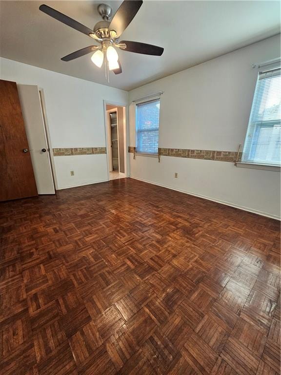 unfurnished room featuring dark parquet floors and ceiling fan