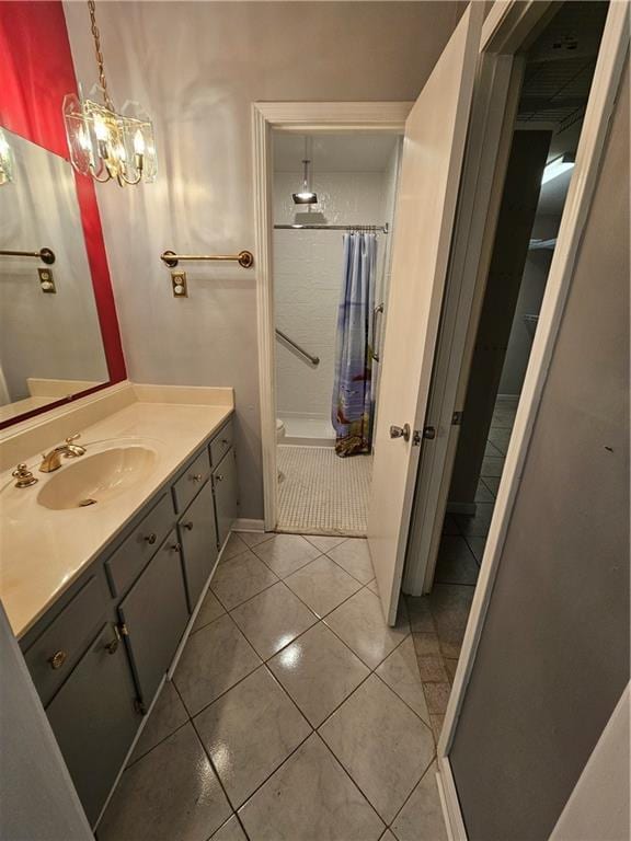 bathroom with a shower with shower curtain, tile patterned flooring, vanity, and a notable chandelier