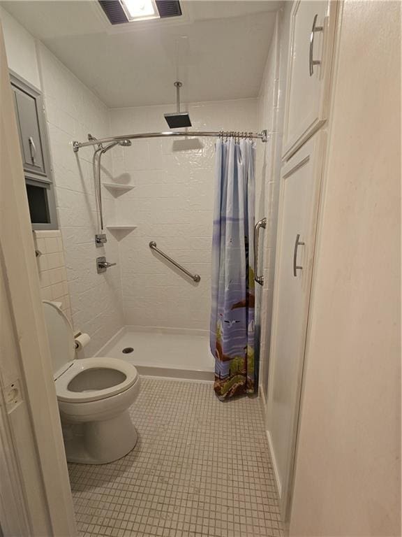 bathroom featuring toilet, tile patterned flooring, and walk in shower