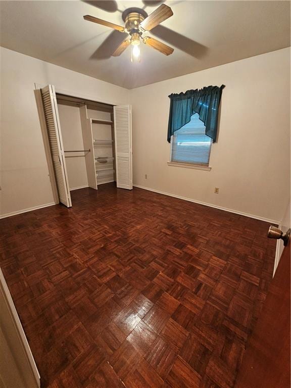 unfurnished bedroom with ceiling fan and dark parquet floors