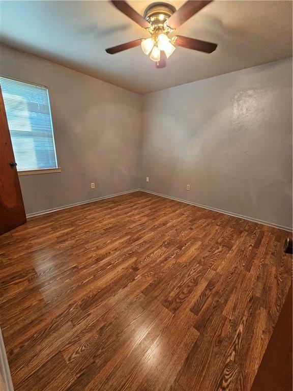 empty room featuring ceiling fan and dark hardwood / wood-style floors