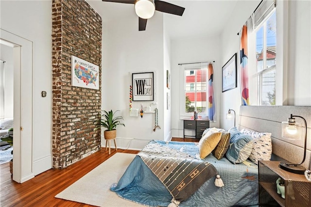 bedroom featuring multiple windows, dark hardwood / wood-style floors, and ceiling fan