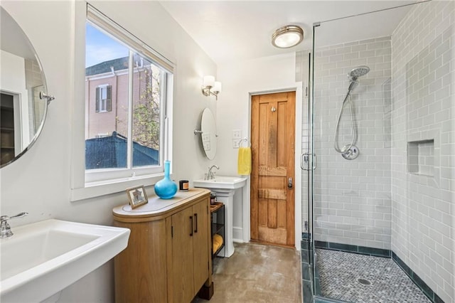 bathroom with dual sinks and walk in shower