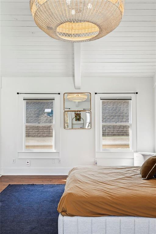 bedroom featuring wood-type flooring, beam ceiling, and wood ceiling