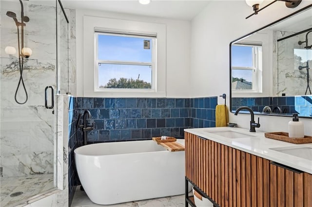 bathroom featuring plus walk in shower, vanity, and tile walls