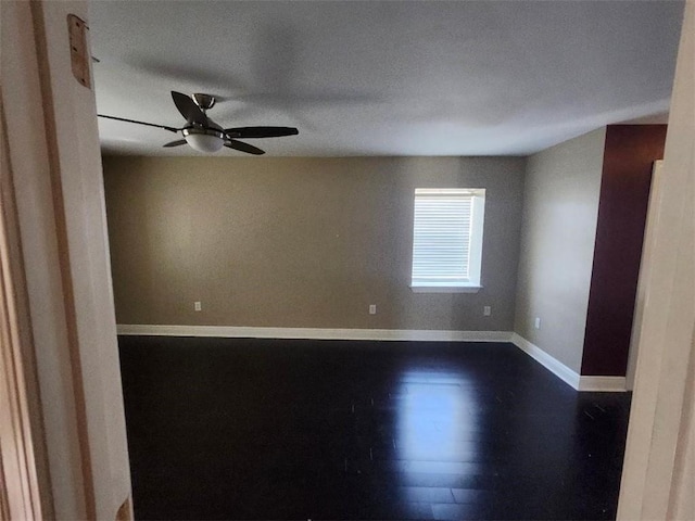 empty room featuring ceiling fan, dark hardwood / wood-style flooring, and a textured ceiling