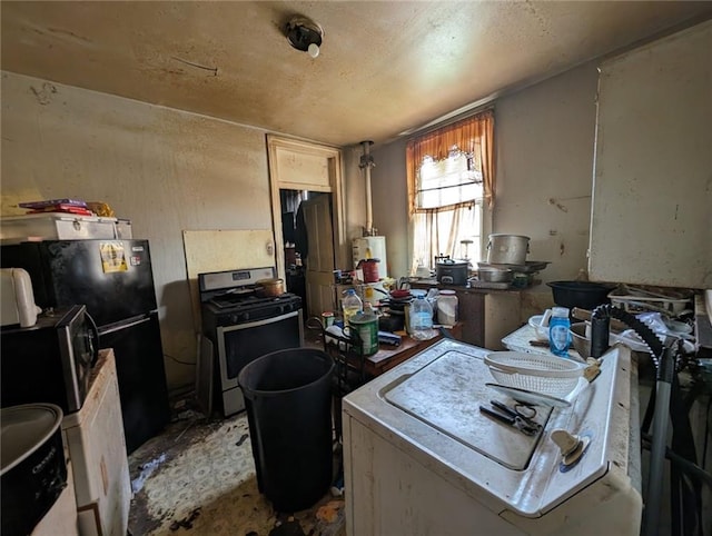 kitchen with stainless steel range with gas cooktop, gas water heater, and black refrigerator