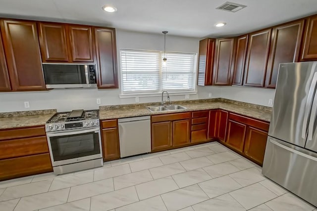 kitchen with stainless steel appliances, decorative light fixtures, and sink