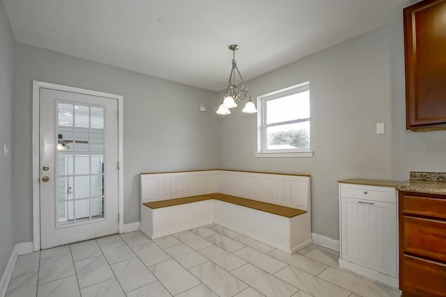 unfurnished dining area featuring ceiling fan with notable chandelier and light tile patterned flooring