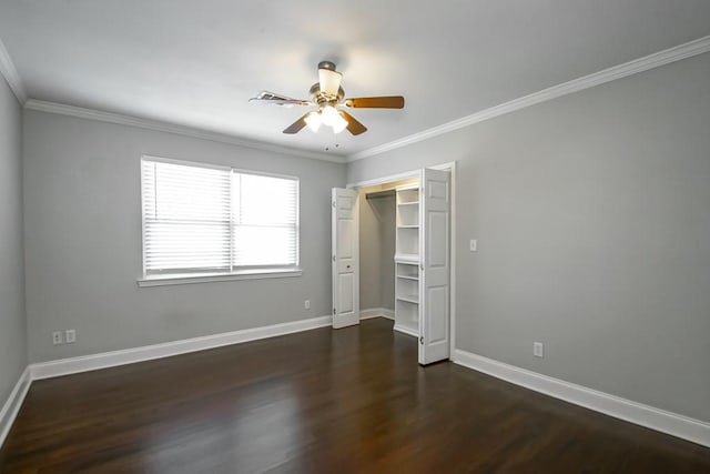 unfurnished bedroom with crown molding, ceiling fan, dark wood-type flooring, and a closet