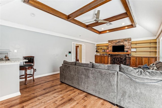 living room with a fireplace, hardwood / wood-style floors, built in features, and ceiling fan