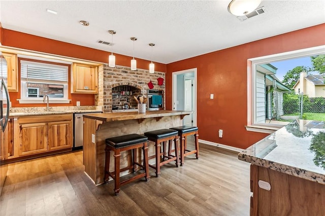 kitchen featuring pendant lighting, sink, appliances with stainless steel finishes, and wood-type flooring