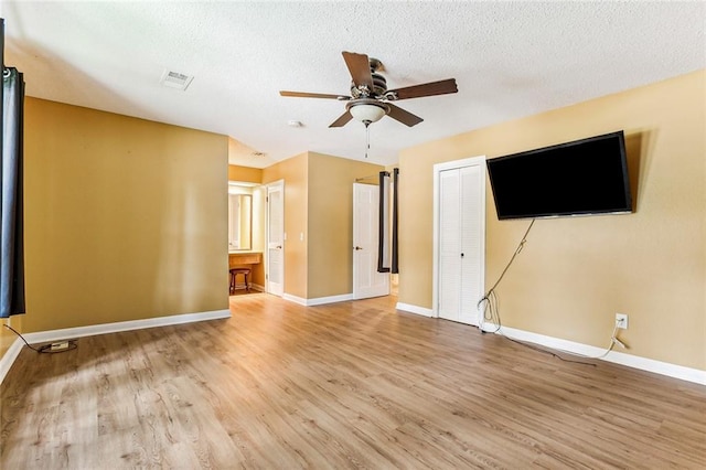 interior space with ceiling fan, a textured ceiling, and light hardwood / wood-style flooring