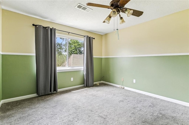 spare room with carpet flooring, ceiling fan, and a textured ceiling