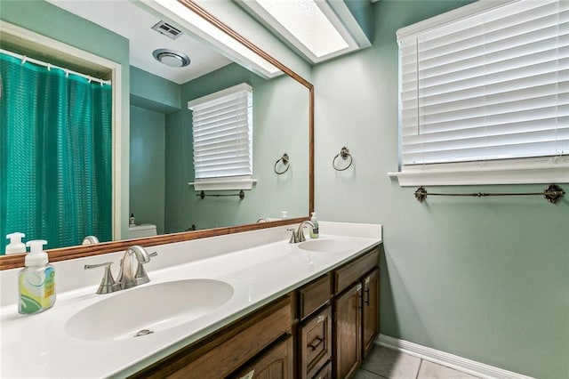 bathroom featuring tile patterned floors, vanity, and toilet