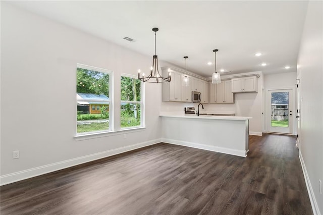 kitchen featuring white cabinets, sink, hanging light fixtures, dark hardwood / wood-style floors, and kitchen peninsula