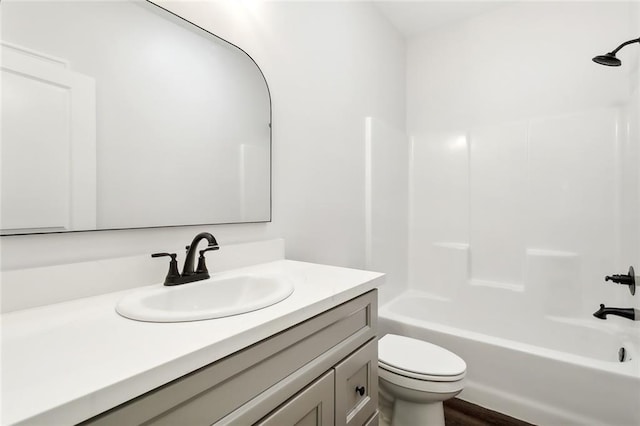 full bathroom with hardwood / wood-style floors, toilet, vanity, and bathing tub / shower combination