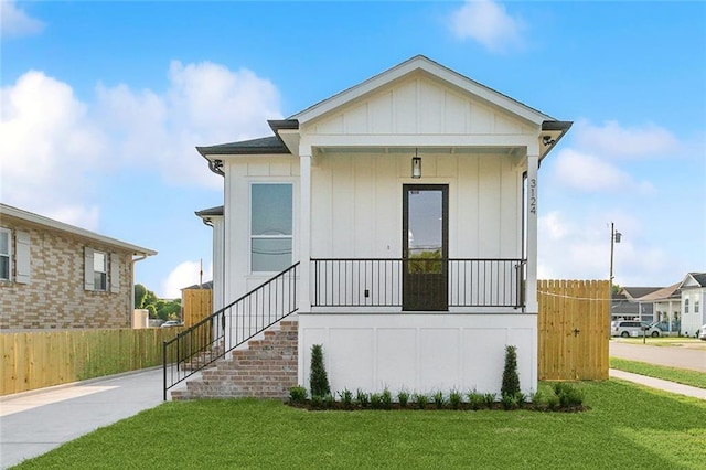 view of front facade featuring covered porch and a front lawn