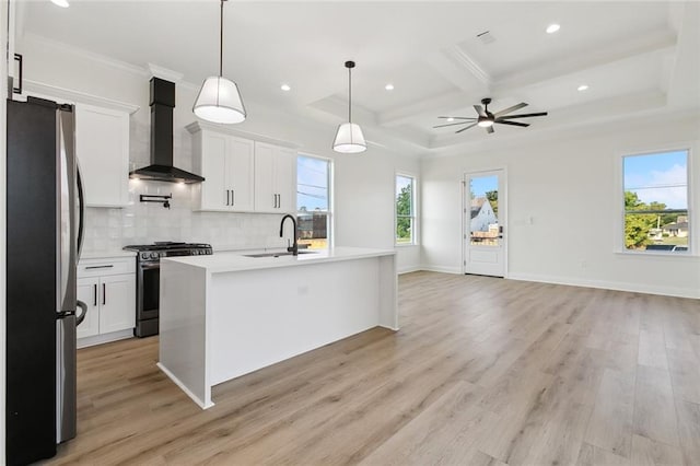 3124 Utah St, Kenner, LA 70065 - kitchen with appliances with stainless steel finishes, wall chimney exhaust hood, a ceiling fan, coffered ceiling, and light wood-style flooring