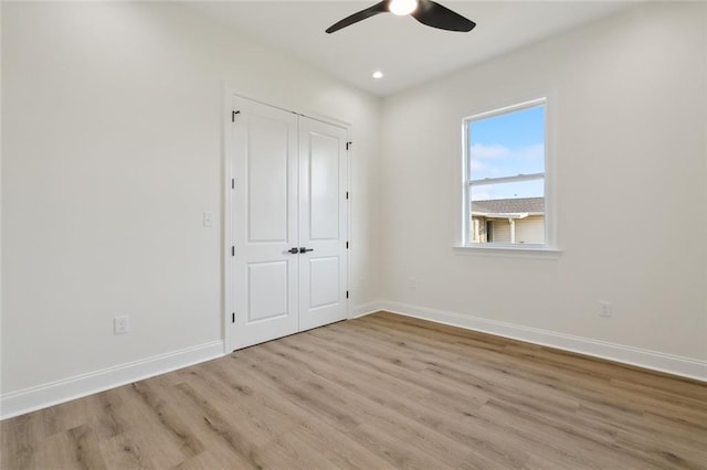 unfurnished bedroom with light wood-type flooring, a closet, and ceiling fan