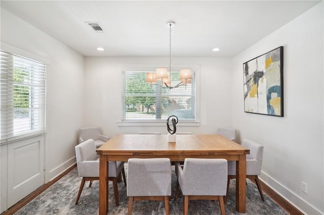 dining space with dark hardwood / wood-style floors and a chandelier