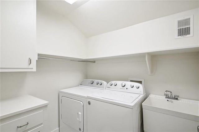 clothes washing area with cabinets, separate washer and dryer, and sink