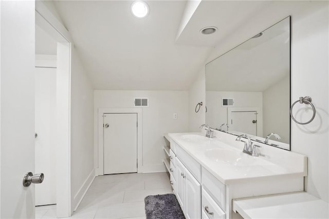 bathroom featuring tile patterned floors, vanity, and vaulted ceiling