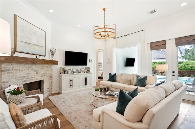 living room with a fireplace, light hardwood / wood-style flooring, french doors, and a notable chandelier