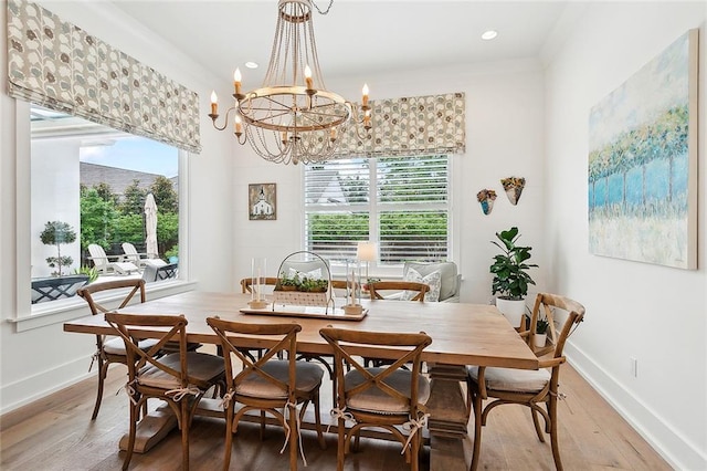 dining room featuring hardwood / wood-style flooring, a healthy amount of sunlight, and an inviting chandelier