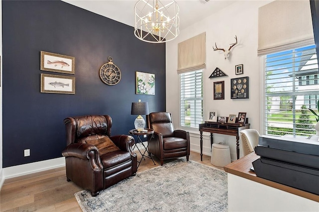 sitting room with hardwood / wood-style flooring and a notable chandelier